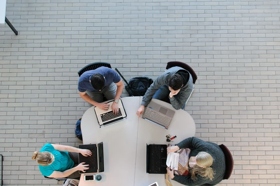 Group working on computers at large table