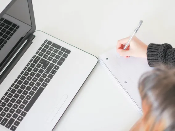 Student writing at her desk