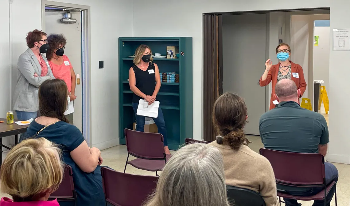 A group of four standing educators speak to an audience about Wildcat Writers